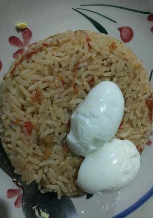A picture of Jollof rice and boiled egg.