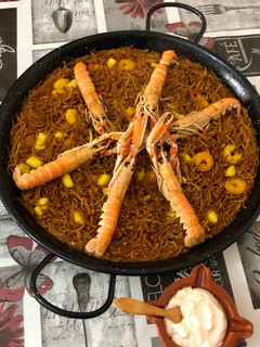Una foto de Fideuá con sepia gambas y cigalas