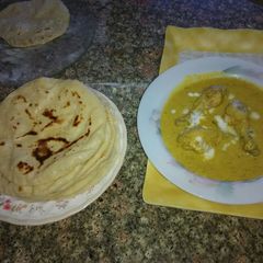 A picture of Chicken curry with lachha paratha.