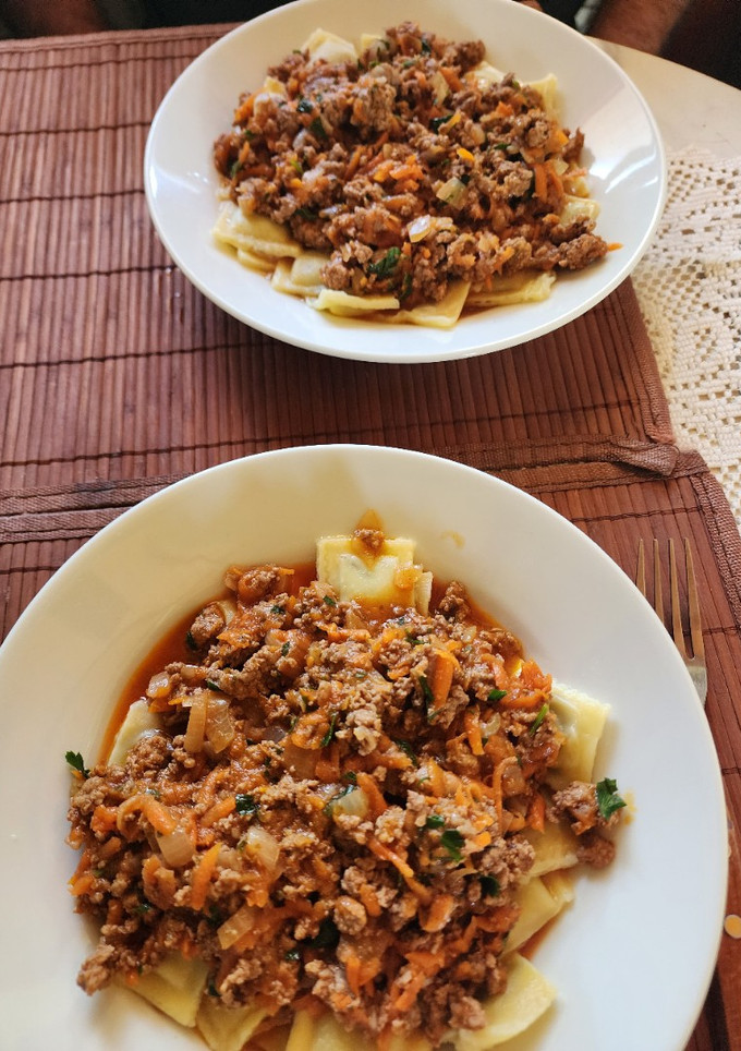 Una foto de Ravioles con salsa y carne y algo más