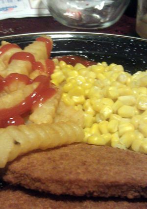 A picture of veal parties with French fries and corn.
