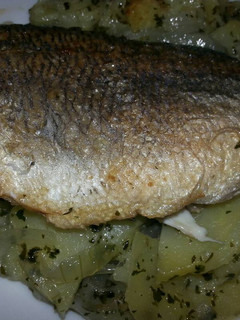 Una foto de Dorada a la sartén en cama de patatas