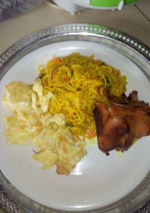 A picture of Turmeric indomi with fried egg and rosted chicken.