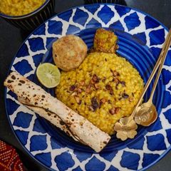 A picture of Lemon Lal Msoor Dal Khichdi With Roasted Papad, Chokha, Dahi And Achar.
