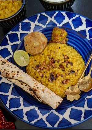 A picture of Lemon Lal Msoor Dal Khichdi With Roasted Papad, Chokha, Dahi And Achar.