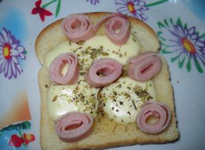 Una foto de Queso ranchero y rulos de jamón sobre tostadas enmantecadas