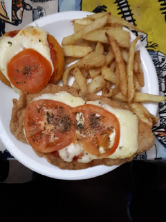 Una foto de Milanesas napolitana con papas fritas