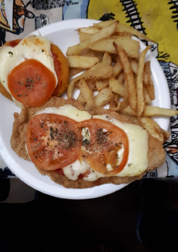 Una foto de Milanesas napolitana con papas fritas