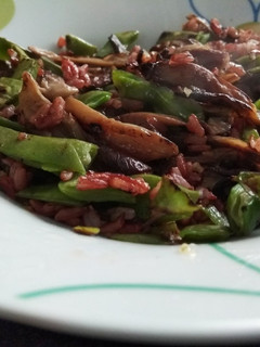 Una foto de Arroz rojo salteado con setas y vainas