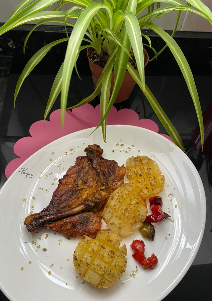 Una foto de Muslos de pollo con patatas al horno