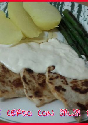 Una foto de Lomo de cerdo con salsa de queso y guarnición