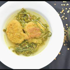A picture of Fiddle head fern and masoor vada curry with lemon.