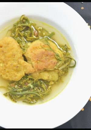 A picture of Fiddle head fern and masoor vada curry with lemon.