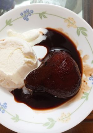 A picture of Poached Pears in Red wine with Ice cream.