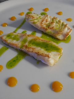 Una foto de Rodaballo con aceite de perejil y cebollino con coolie de mango