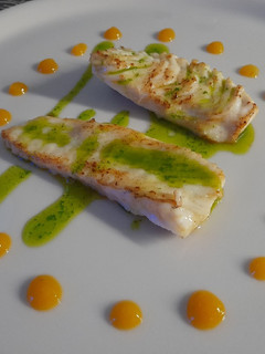 Una foto de Rodaballo con aceite de perejil y cebollino con coolie de mango