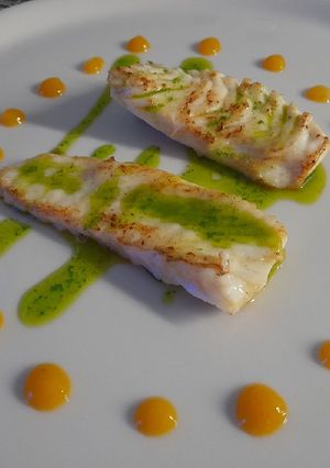 Una foto de Rodaballo con aceite de perejil y cebollino con coolie de mango