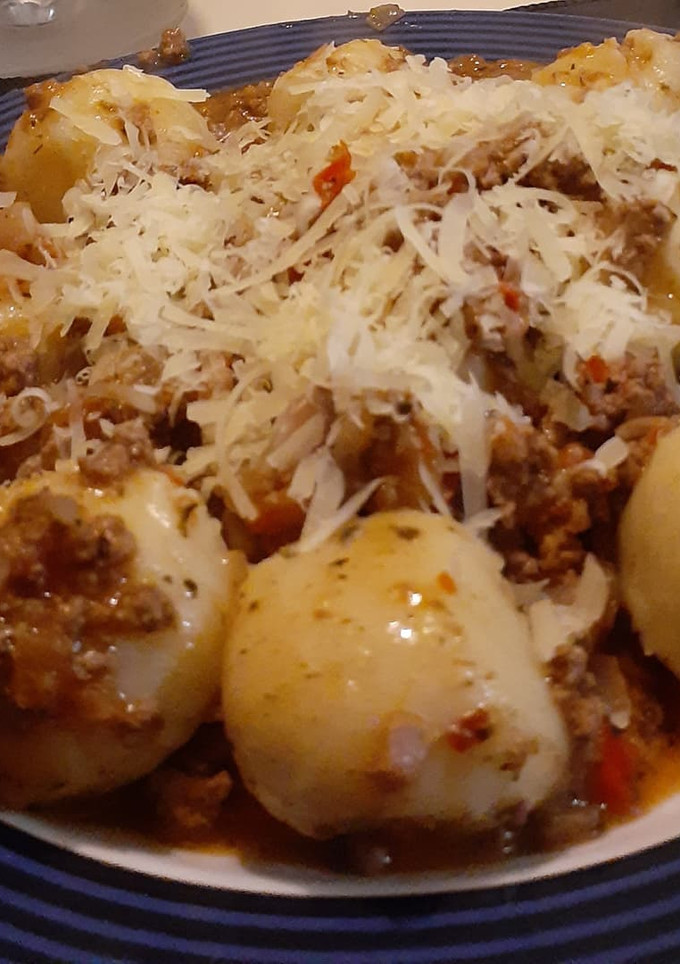 Una foto de Ñoquis rellenos con jamón y queso, salsa bolognesa