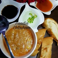A picture of Hot and sour soup with cheesy bread stick.