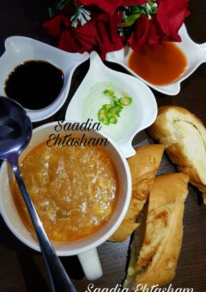 A picture of Hot and sour soup with cheesy bread stick.