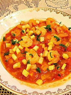 Una foto de Colas de gambas en salsa de tomate al ajillo y patatas fritas