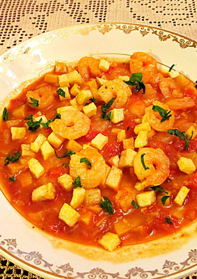 Una foto de Colas de gambas en salsa de tomate al ajillo y patatas fritas