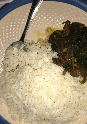 A picture of Rice with ugu soup.
