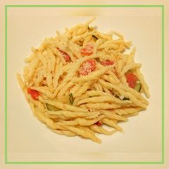 A picture of Trofie pasta with fresh tomatoes and courgette.