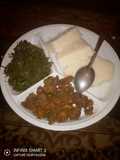 Ugali served with marinated beef and steamed spinach