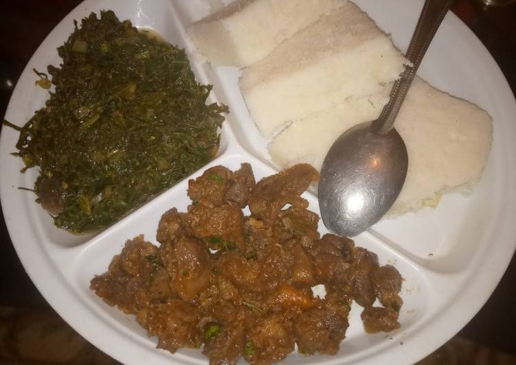 Ugali served with marinated beef and steamed spinach