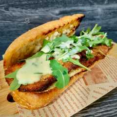 Foto di Bocadillo de pollo marinado empanado con rúcula y salsa de parmesano