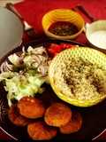 Plato de falafel con arroz aromatizado, ensalada con hierbabuena y salsas de yogur y tomate