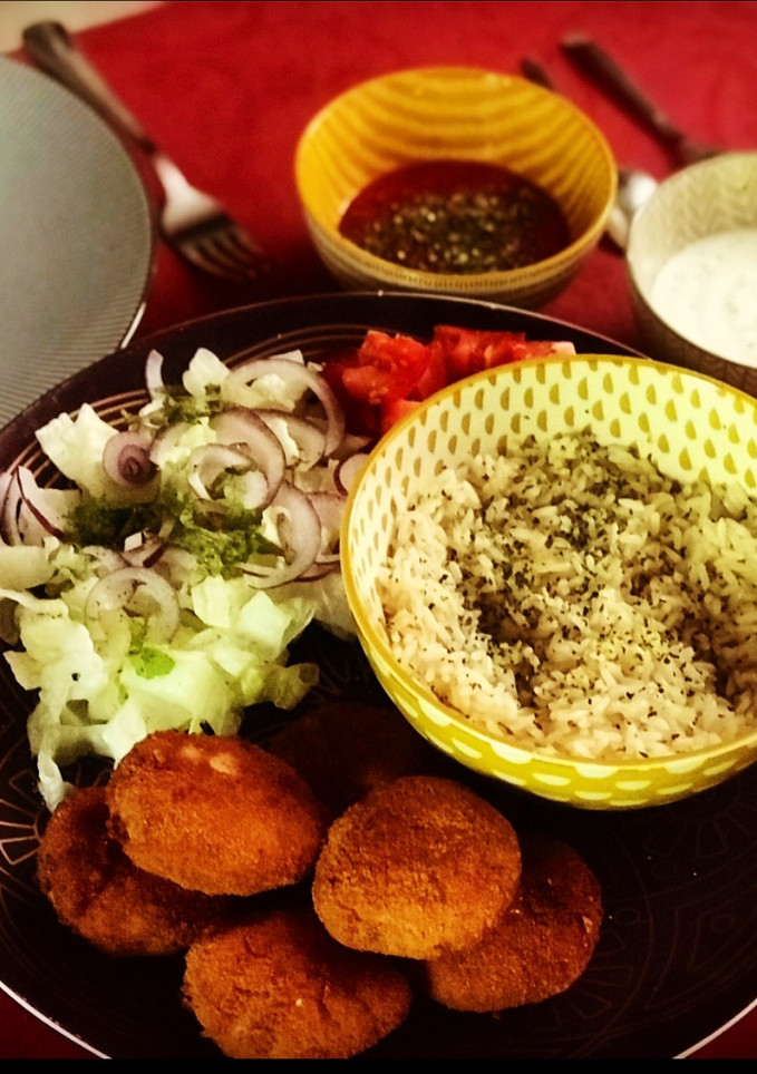 Una foto de Plato de falafel con arroz aromatizado, ensalada con hierbabuena y salsas de yogur y tomate