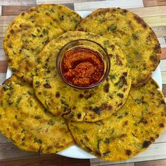 A picture of Makka methi paratha with garlic chutney.