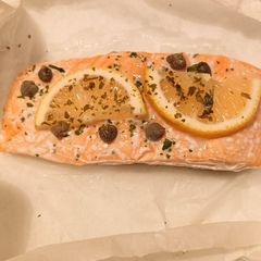 A picture of Salmon with lemon, capers and parsley.