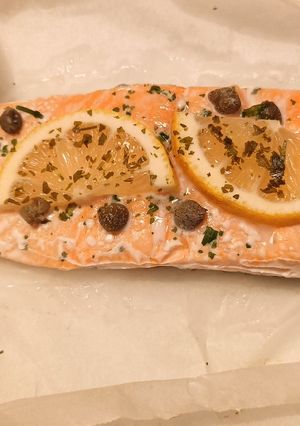 A picture of Salmon with lemon, capers and parsley.
