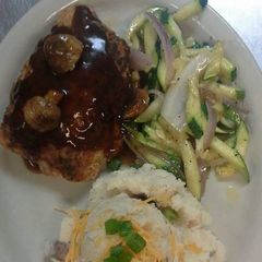 A picture of Stuffed pork chop topped with mushroom bordelaise sauce.