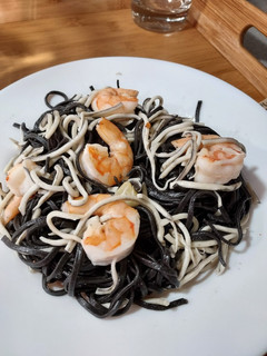 Una foto de Pasta negra con gulas y langostinos