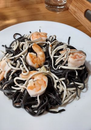 Una foto de Pasta negra con gulas y langostinos