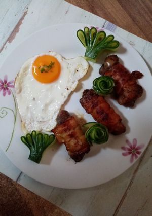 Csirkemáj baconbe tekerve lágy tojással, kígyóuborka dísszel recept fotója