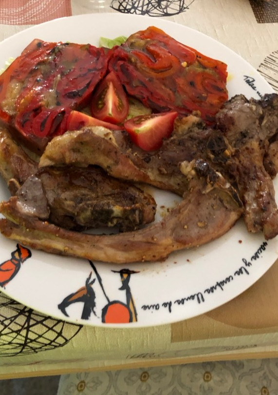 Una foto de Chuletas de cordero con pastel de pimientos y berenjena