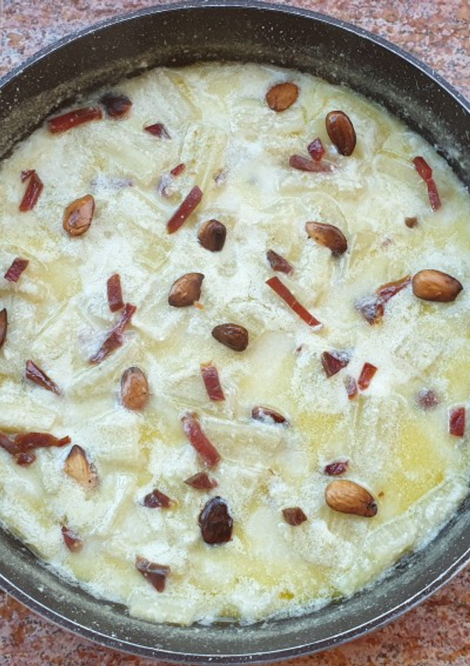 Una foto de Cardo con salsa de almendras y virutas de jamón