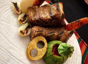 Una foto de Costilla de cerdo con vegetales al grill y salsa de tuna al vino tinto