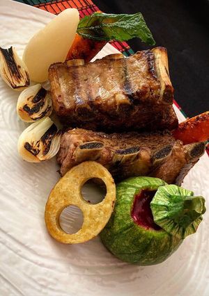 Una foto de Costilla de cerdo con vegetales al grill y salsa de tuna al vino tinto