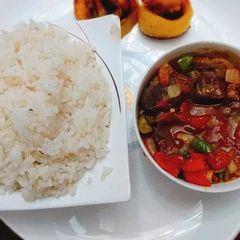 A picture of Boiled rice with tomato gizzard sauce.