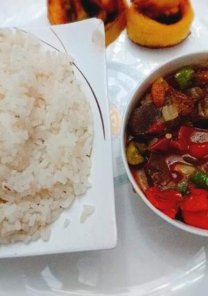 A picture of Boiled rice with tomato gizzard sauce.