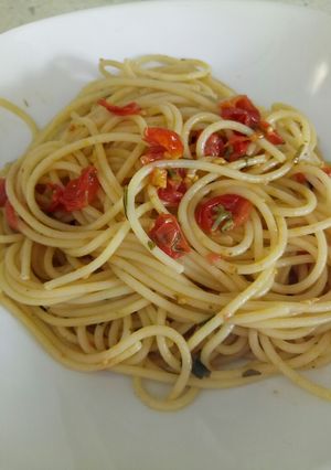 A picture of Spaghetti with fresh cooked tomatoes and fresh herbs.