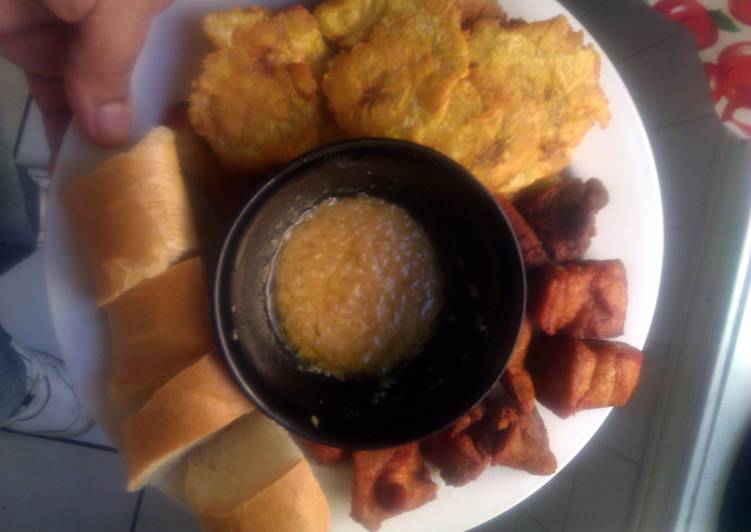 Carnitas fritas con tostones garlic sauce and long bread...