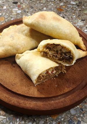 Una foto de Empanadas criollas (morrón, cebolla, huevito duro, pasa de uva y aceitunas), con masa casera🥟