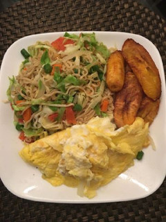 A picture of Indomine with fried plantain,fried egg and vegetables.
